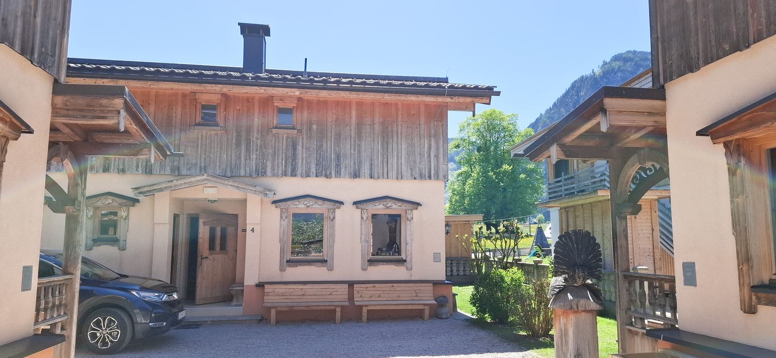 Eingangsbereich des Ferienhauses Eberharter mit SitzbÃ¤nken und Parkplatz