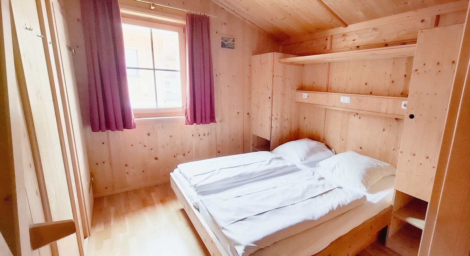 Schlafzimmer 4 mit Doppelbett und VorhÃ¤ngen im Ferienhaus Eberharter